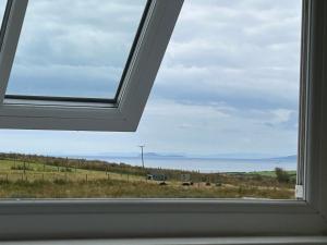 a window in a room with a view of a field at Sanda View, Isle of Arran in Sliddery