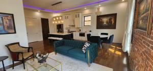 a living room with a blue couch and a kitchen at The Luxe Building- 2 Bedroom Apartment in Metropolis in Metropolis