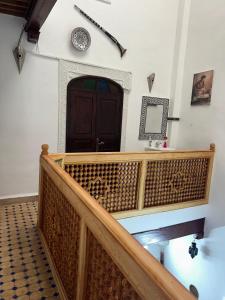 a wooden staircase with a brown door and a clock on the wall at DarMouniaFès in Fez