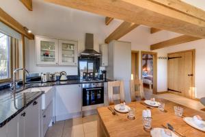 a kitchen with a wooden table in a kitchen with a tableablish at 2 Bed in Tenterden oc-tn606 in Stone
