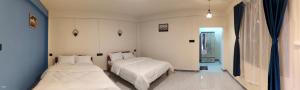 a bedroom with two beds and a hallway with a window at Eyana Residency in Lāitlyngkot