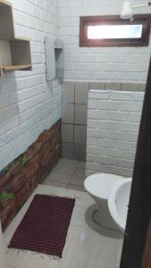 a bathroom with a toilet and a sink at Portal de maria in Imbituba +15 photos