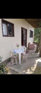 a table and benches in front of a house at Portal de maria in Imbituba
