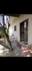 a house with a table and a tree in front of it at Portal de maria in Imbituba