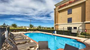 a swimming pool with chairs and a hotel at Hampton Inn & Suites Houston Rosenberg in Rosenberg