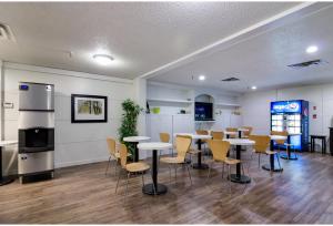 a dining room with tables and chairs in a building at Motel 6 Kerrobert, SK in Kerrobert
