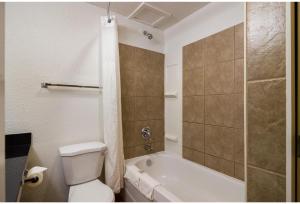 a bathroom with a tub and a toilet and a shower at Motel 6 Kerrobert, SK in Kerrobert +24 photos