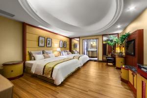 um quarto de hotel com duas camas e uma televisão de ecrã plano em Chuang-Tang Spring SPA Hotel - Deyang em Jiaoxi