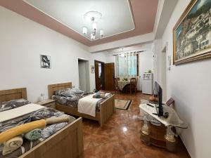 a bedroom with two beds and a living room at Guest House Flowers in Berat