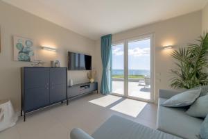a living room with a large sliding glass door at Le Suites sul Mare di Esterina in Civitavecchia