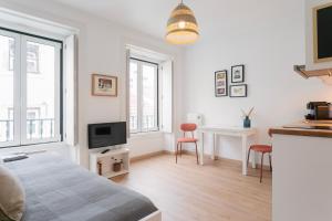 a white room with a bed and a desk and two chairs at Severa Apartments in Lisbon +60 photos