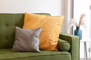 a green couch with two pillows on it at Severa Apartments in Lisbon