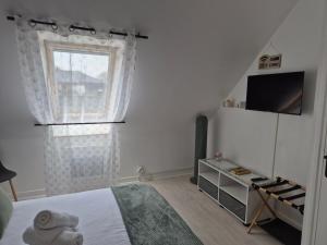 a bedroom with a bed and a window at Chez Ninie in Le Cloître-Saint-Thégonnec