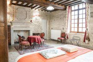 a room with a table and chairs and a fireplace at La Ferme de la Gronde in Magny-en-Bessin