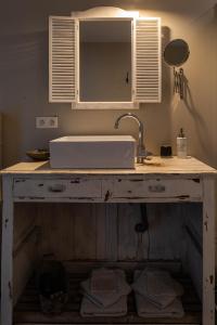 a kitchen counter with a sink and a mirror at B&B Kamer en Aambeeld in Zoutleeuw +15 photos