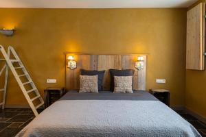a bedroom with a large bed with a wooden headboard at B&B Kamer en Aambeeld in Zoutleeuw