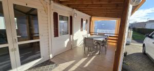 a porch of a house with a table and chairs at location mobile home proche de la mer in Hermanville-sur-Mer