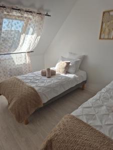 a bedroom with a bed with pillows and a window at Chez Ninie in Le Cloître-Saint-Thégonnec