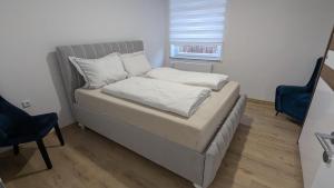 a bed with two pillows on it in a room at Heideperle, Ferienhaus in Schneverdingen