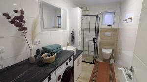 a white bathroom with a sink and a toilet at Heideperle, Ferienhaus in Schneverdingen +20 photos