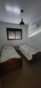 a bedroom with two beds and a window at The Yerbal Thermal House in Termas de Guaviyú