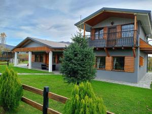ein Haus mit einem Zaun davor in der Unterkunft Simon's Walnut Farm in Kastoria