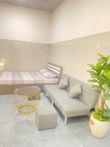 a living room with a couch and a bed at Homestay Vườn Dừa in Ấp Nhứt (1)