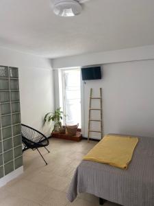 a bedroom with a bed with a yellow blanket on it at Quarto, Algarve in Olhão