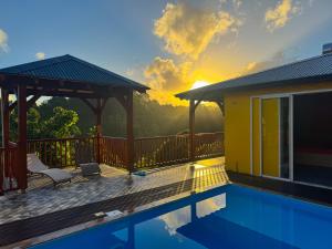 a house with a swimming pool and a gazebo at Bungalow Racoon Le Gosier in Le Gosier