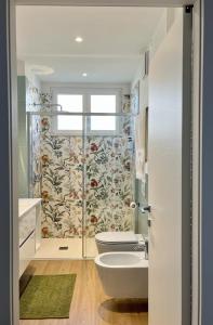a bathroom with a toilet and a sink and a window at The Cozy Peak - 360 Dolomites View in Agordo +30 photos