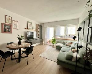 a living room with a green couch and a table at The Cozy Peak - 360 Dolomites View in Agordo