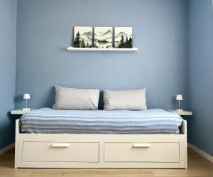 a bedroom with a bed with a blue wall at The Cozy Peak - 360 Dolomites View in Agordo