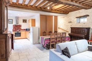 a living room with a couch and a kitchen at La Ferme de la Gronde in Magny-en-Bessin