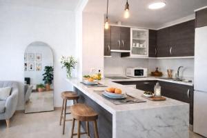 a kitchen with a large island with bar stools at Noctua Manilva Sea View 023 in Manilva