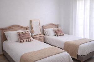 two beds in a room with white walls at Noctua Manilva Sea View 023 in Manilva