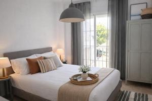 a bedroom with a bed with a table with flowers on it at Noctua Manilva Sea View 023 in Manilva