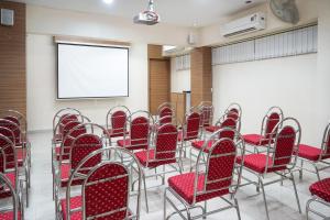 ein leeres Zimmer mit roten Stühlen und einem Bildschirm in der Unterkunft Hotel Sonia CIDCO in Aurangabad