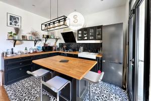 a kitchen with a wooden table and a refrigerator at L'Orangeraie Arles in Arles