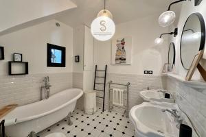 a bathroom with two sinks and a tub and a toilet at L'Orangeraie Arles in Arles +28 photos
