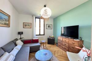 a living room with a couch and a flat screen tv at L'Orangeraie Arles in Arles