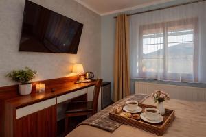 a hotel room with a table with a tray of food at WILLA PETRUS - CENTRUM BALKONY WINDA ŚNIADANIA RELAKS I WYGODa in Karpacz +63 photos