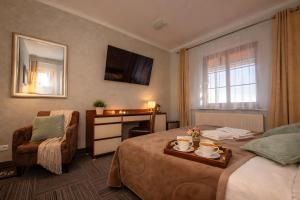 a hotel room with a bed and a chair at WILLA PETRUS - CENTRUM BALKONY WINDA ŚNIADANIA RELAKS I WYGODa in Karpacz