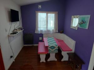 a room with a table and a purple wall at Ushuaia centro Complejo de Cabañas in Ushuaia