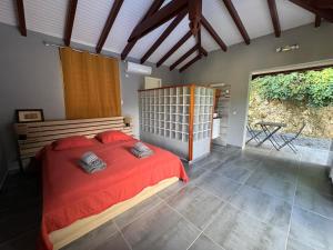 a bedroom with a large bed with red sheets at Bungalow Racoon Le Gosier in Le Gosier +22 photos