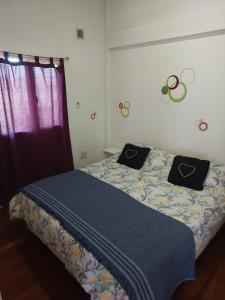 a bedroom with a bed with black pillows on it at Ushuaia centro Complejo de Cabañas in Ushuaia