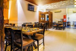 uma sala de jantar com mesa e cadeiras com pratos e copos em Hotel Sonia CIDCO em Aurangabad