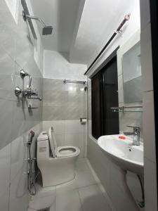 a white bathroom with a toilet and a sink at Kathmandu Valley View Homestay in Kathmandu