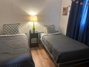 a bedroom with two beds and a table with a lamp at Entire Vacation home blocks to the Strip, ARTS Dist, & Main Street Sleeps up to 8 in Las Vegas +29 photos