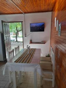 a dining room with a table and a tv on the wall at Ave del Paraíso in Colón