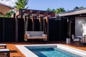 a patio with a swing and a swimming pool at Arenal Manoa Hot Springs Resort in Fortuna